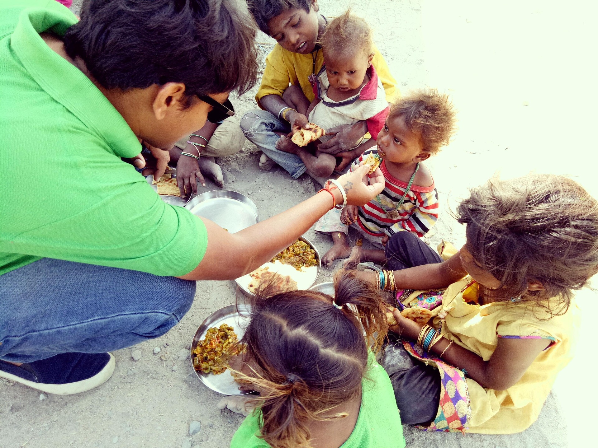 A volunteer sharing a meal with children in need