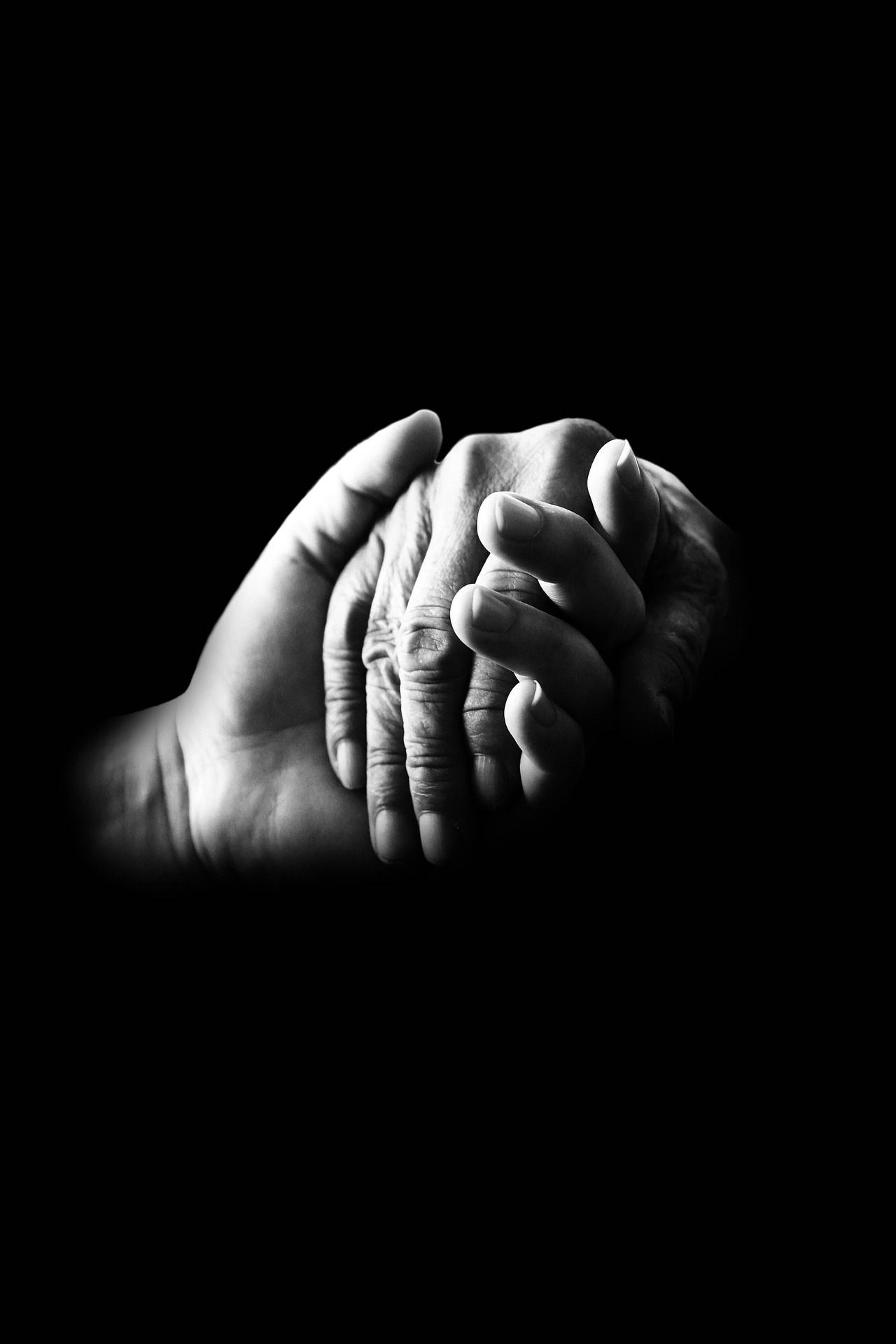 Two hands clasped together in a gesture of comfort and support